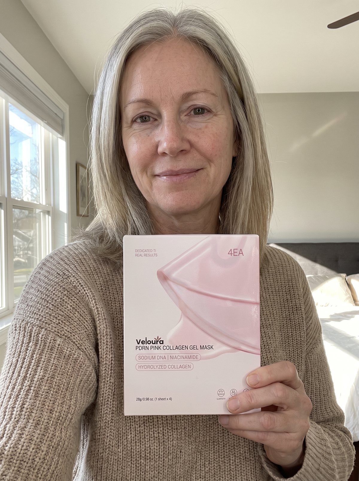 Holding a box of Veloura PDRN Pink Collagen Gel Masks at home.